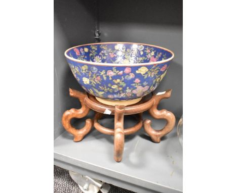 A 20th century Chinese Qianlong style Famille Rose bowl, decorated with flowers and foliage on a cobalt ground, four red char