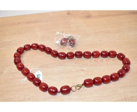 A red resin beaded necklace, having beads of oval form with matching earrings