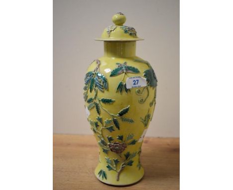 A Chinese porcelain yellow glazed and lidded baluster vase, moulded in relief with foliate detail and two butterflies, moulde