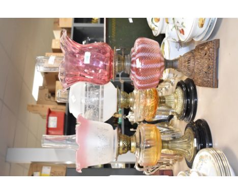 A 19th century oil lamp having flared cranberry glass shade and two level burners, raised on a square metal base, h57cm, sold
