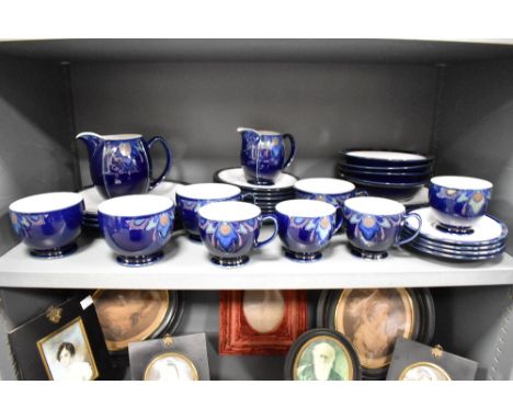 A Denby part dinner service, decorated with floral patterns on a colbalt ground, to include cups and saucers, ( 33 )