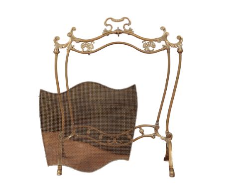 AN EDWARDIAN BRASS FIRESCREEN the serpentine cresting rail with pierced and scrolled moulding, with a wire mesh panel beneath
