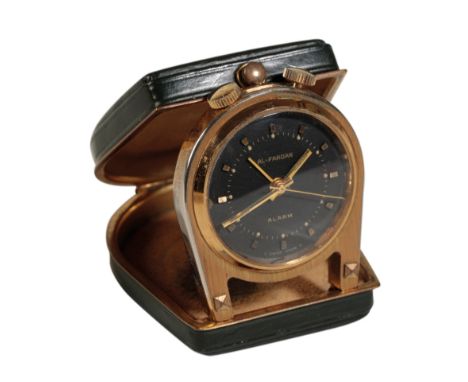 AL-FARDAN: A MINIATURE BRASS PURSE ALARM CLOCK with manual key wind movement, the black dial with gold baton numerals and gol