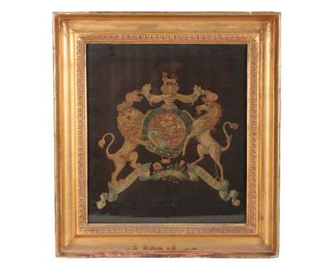 A 19TH CENTURY EMBROIDERED TAPESTRY depicting the royal coat of arms, 45cm high x 40cm wide, within a gilt wood frame, ascrib