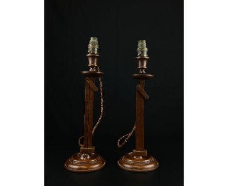 A pair of unusual C.1900 mahogany table lamps each having an octagonal tasseled pagoda shaped shade above a turned finial ove