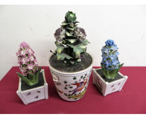 Continental ceramic jardinière with twin face mask handles decorated with exotic birds, with ceramic faux floral arrangement 