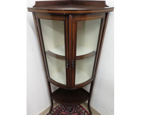 Edwardian mahogany inlaid floor standing, bow front corner cabinet with 2 upper closed doors above open shelf to the base. (W