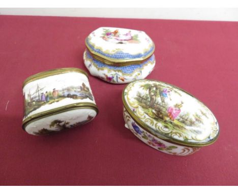 A oval circular porcelain table box with gilt mounts floral and gilt detail and central panel of couple with blue cross sword
