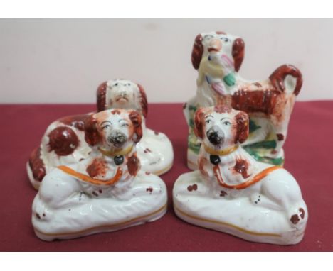 Pair of Staffordshire Spaniels with painted decoration and yellow collars, on oval bases (H7.5cm); a similar seated model of 