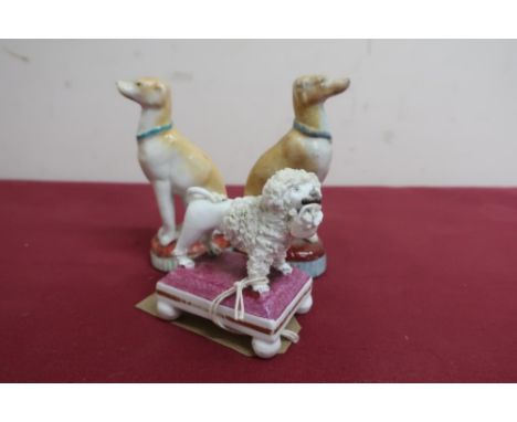19th C English porcelain model of a poodle with a basket of flowers on a rectangular base with four ball feet (H7cm); pair of