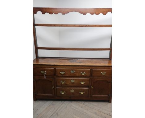 George III oak dresser, twin shelf back with shaped frieze above two real and one faux drawers enclosed by stepped arch cupbo