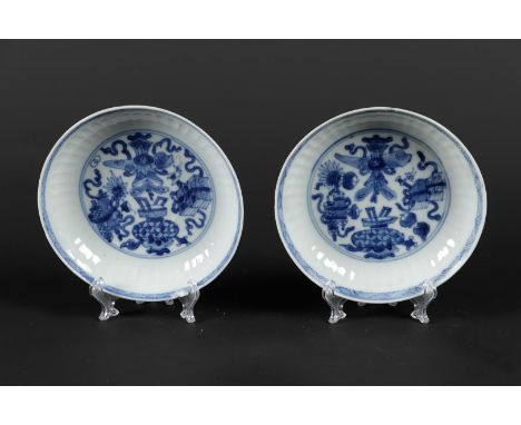 Twee geribde porseleinen bordjes met antiquiteiten decor, met zegel gemerkt. China, Kangxi. 