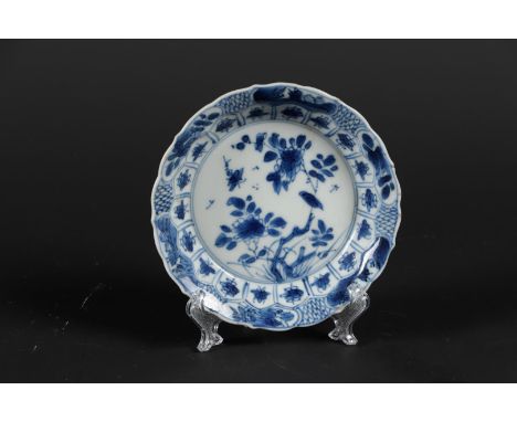 Een porseleinen diep bordje met floraal decor, waartussen insecten. Met zegelmerk gemerkt. China, Kangxi. 