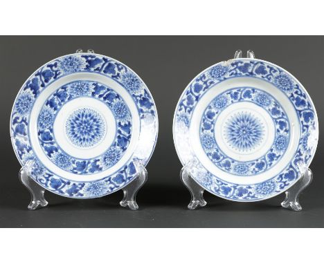 Twee porseleinen borden met floraal decor en met rozet in de midden, achterzijde met tao•stisch merk (2x vissen). China Kangx