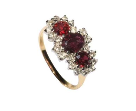 Handsome ruby and diamond yellow and white 18ct gold ring, having three rubies totalling approximately 2 carats, bordered wit