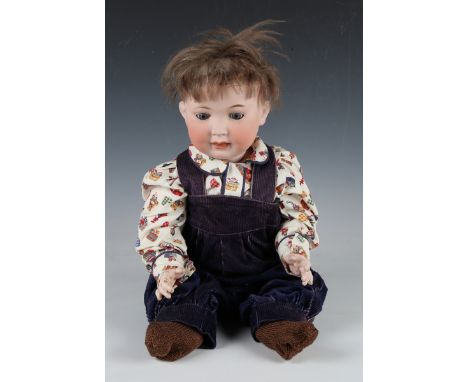 A German bisque head doll, impressed '914', with brown wig, sleeping eyes, open mouth and bent limb composition body, height 