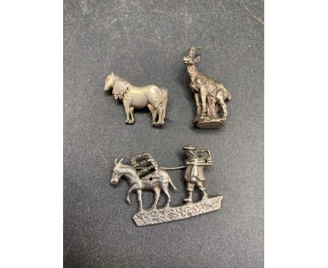 Two silver pony brooches and one miniature goat statue
