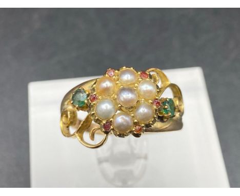 An Edwardian Emerald, Ruby and Pearl fancy scrolled ring in high carat Size O