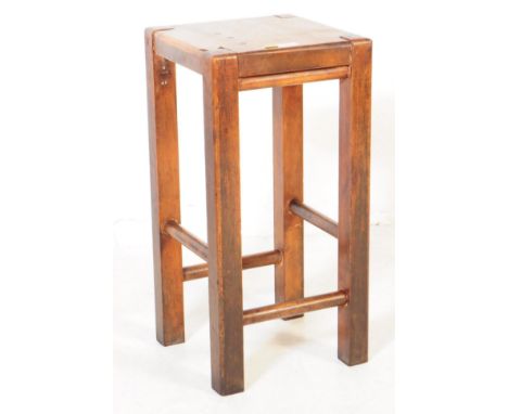 An early 20th century rustic oak wood farmhouse stool / side table. The table raised of square form, raised on long block leg