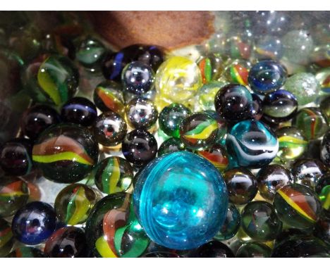 A vintage tin by the Co-operative Wholesale Society Ltd containing a quantity of modern and vintage marbles