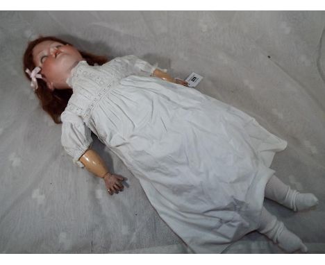 An Armand Marseille bisque headed dressed doll with multiple jointed arms and legs, sleeping eyes, open mouth displaying teet
