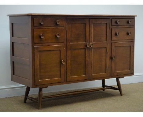 Ercol medium elm sideboard, four graduating drawers, one large cupboard flanked by two small, tapering supports, W131cm, H87c