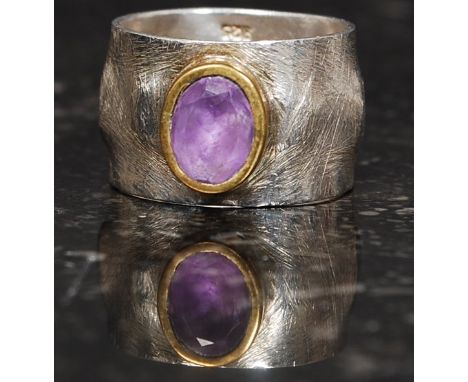 A designer silver 925 band ring with central amethyst stone with yellow metal mount. Size R.5. 8.5g

FREE UK POSTAGE ON ALL L