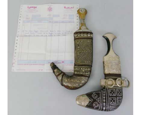 An Arabian jambiya dagger, with 19cm steel ribbed double edged curving blade and white metal mounted horn handle, in white me