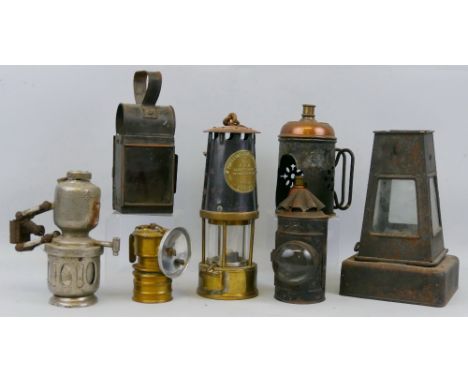 Seven various hand lamps, including miner's brass and steel safety lamp by The Protector Lamp and Lighting Company 25cm high,
