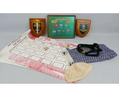 A headdress for the Trucial Oman Scouts, two wooden mounted military transport shields, a framed print of Gurkha cap badges a