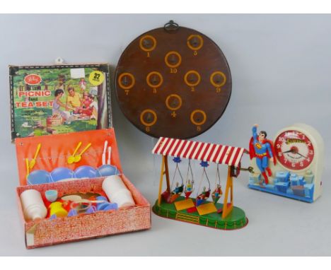 A JW Germany clockwork tin-plate fairground swinging boats ride, 22cm wide, an Equity Taiwan Superman talking alarm clock 18c