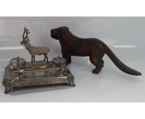 An early 20thC silver plated ink standish, with glass inkwells and stag centrepiece with long tailed terrier nutcracker.