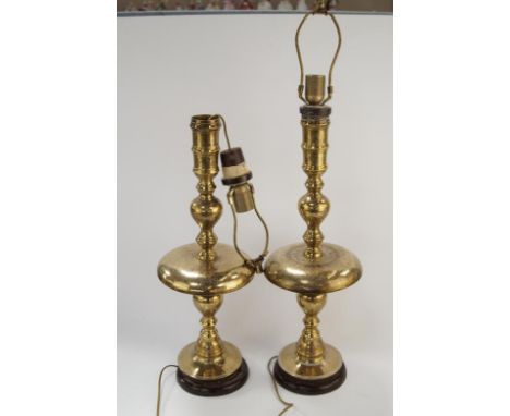 Two Middle Eastern brass light stands, upon mahogany plinths, height of fitting without shade 60cm.