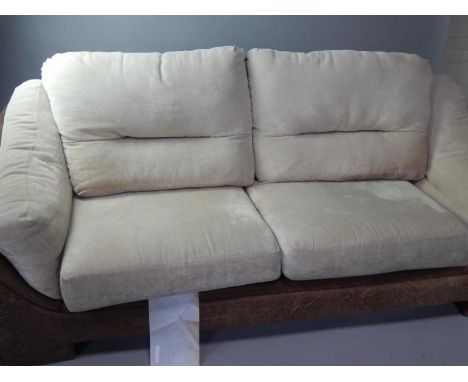 A leatherette finish three seater sofa, with cream chenille upholstered cushions.