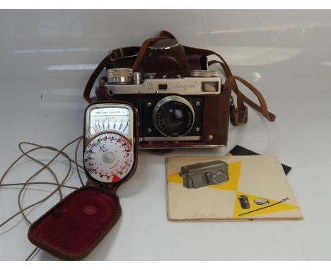 A Leningrad SLR camera, with assorted paperwork and a light meter.