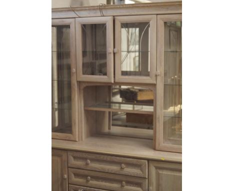 A lime washed beech unit, comprising of two centre cupboard doors leading to a central shelf, flanked by two glazed doors eac