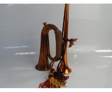 A copper and brass hunting horn, with a copper and brass military style bugle horn.