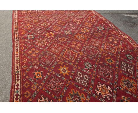 A Middle Eastern large knotted carpet, on red ground, 462cm x 214cm.