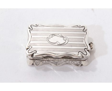 Victorian silver vinaigrette of shaped rectangular form, with engine turned decoration and hinged cover, opening to reveal a 