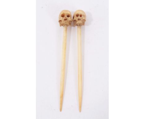 Unusual pair of 19th century macabre carved ivory cocktail sticks, with skull terminals, 9.5cm long