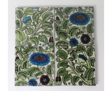 Panel of four late 19th century tiles by William de Morgan, painted in the Iznik style with blue and purple flowers and meand