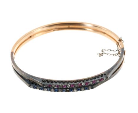 Late 19th Century French diamond, ruby and sapphire double-row hinged bangle with two bands obliquely set with rubies and sap