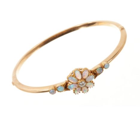 Edwardian opal and diamond hinged bangle, the flower head cluster with a central old cut diamond, cabochon opal petals and fu