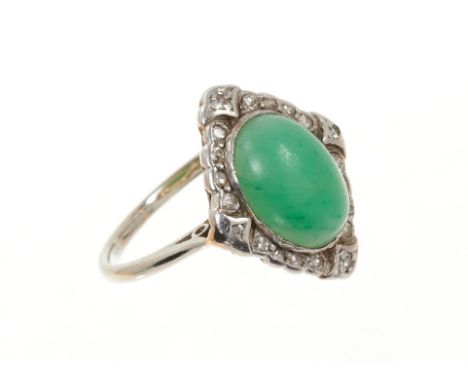 1920s jade and diamond cluster ring with an oval jade cabochon surrounded by a border of single cut diamonds in platinum and 