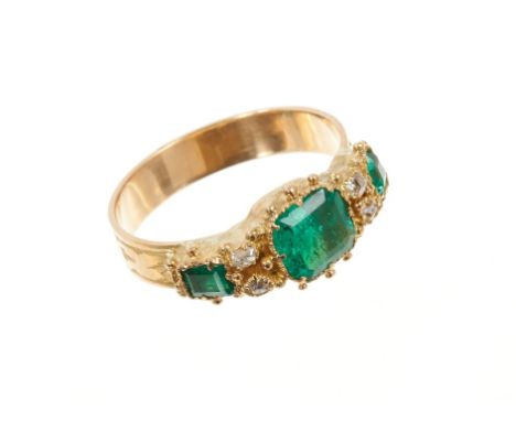 Victorian style emerald and diamond ring with three step cut emeralds and four old cut diamonds all in closed-back gold setti