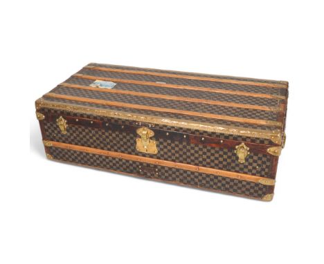A Vintage French travelling trunk, brass wood and leather-bound with printed canvas panels, Damier pattern, 111cm x 54cm x 34