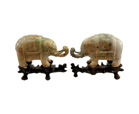 A small pair of Chinese carved jade elephant on carved wood stand, length 10.5cm Tusks and trunk have been damage and repaire