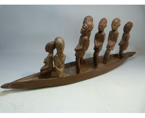 African carved canoe with standing people.