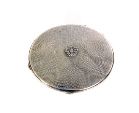 An Art Deco silver compact, having marcasite flower to top, engine turned design to both sides, marked London