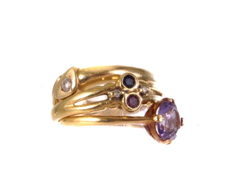 An 18ct gold and gem set dress ring, the red and blue round cut stones, flanked by two smaller clear stones, together with an